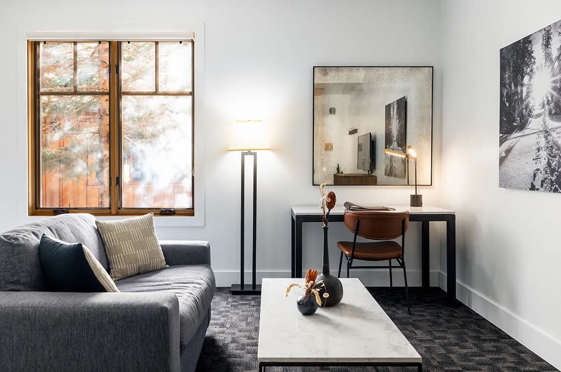 DLX Powderhound room — larger guest room with sitting area and desk workspace, natural light