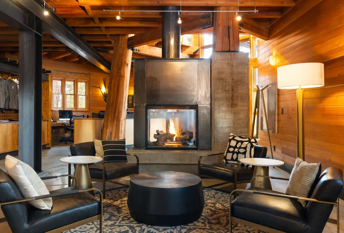 Gravity Haus lobby with central fireplace — wood beams and stone, social gathering space