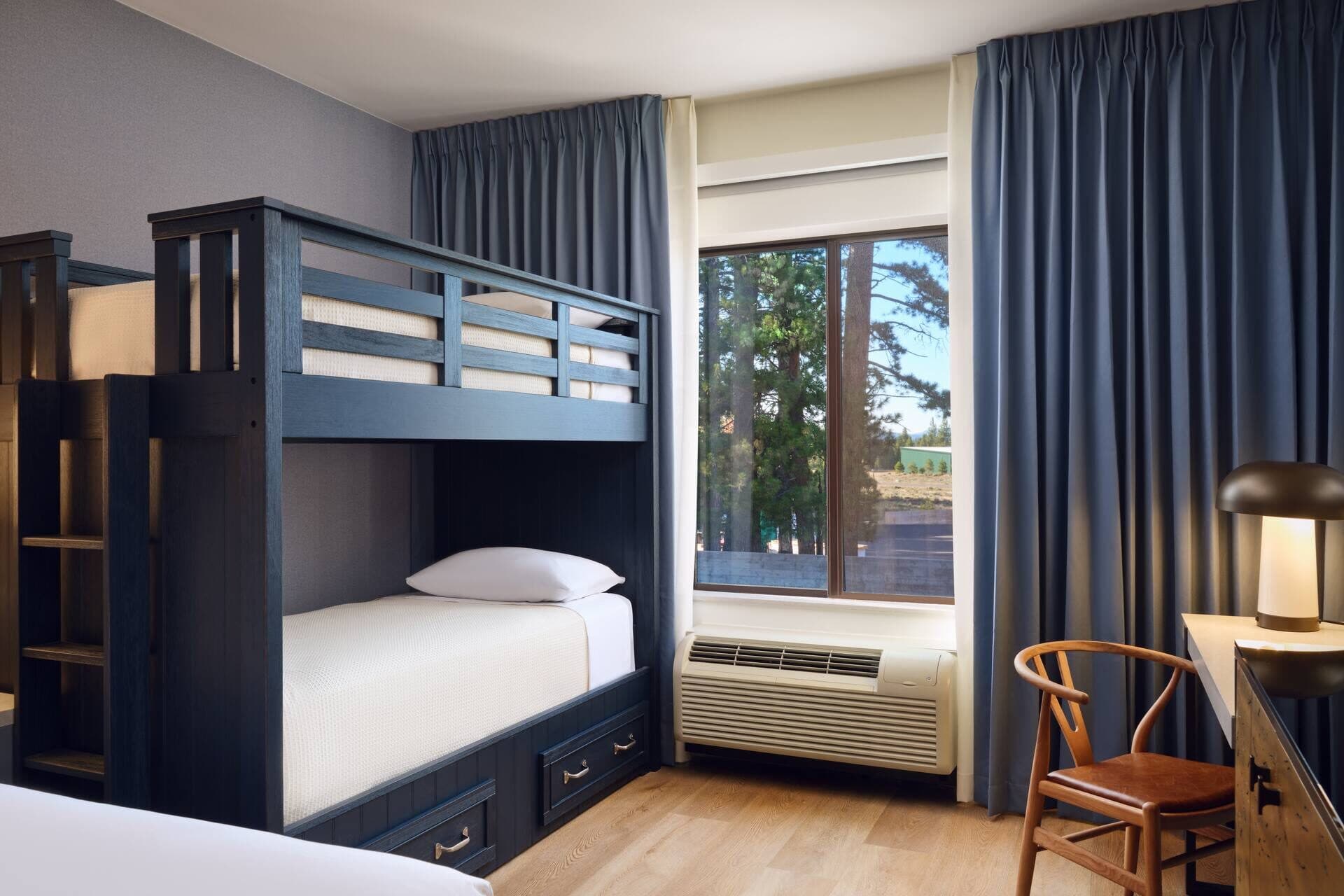 Family guest bedroom with twin bunk beds and work desk at Martis Valley Lodge