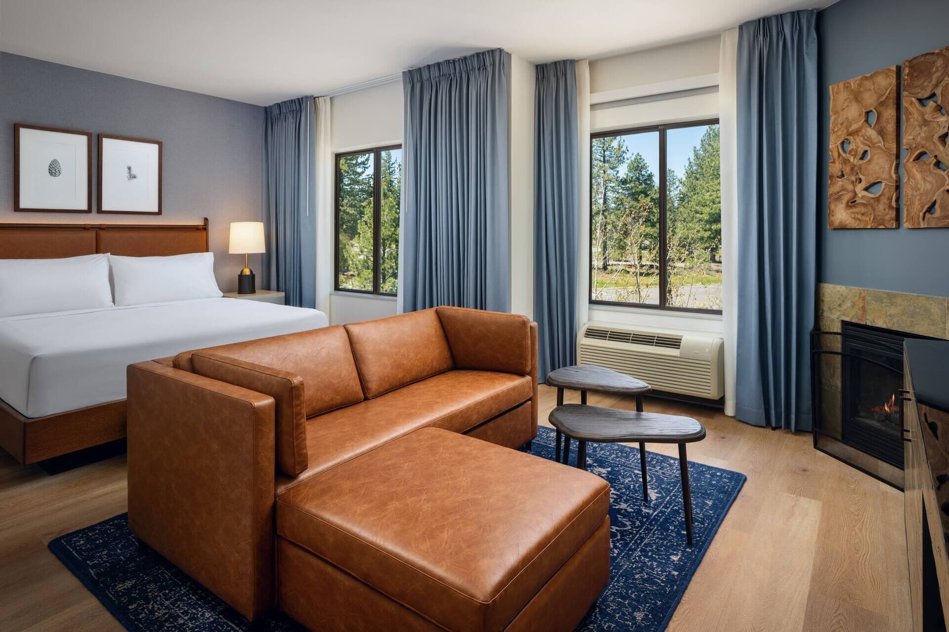 King junior suite at Martis Valley Lodge with fireplace, leather ottoman seating, and wood floors