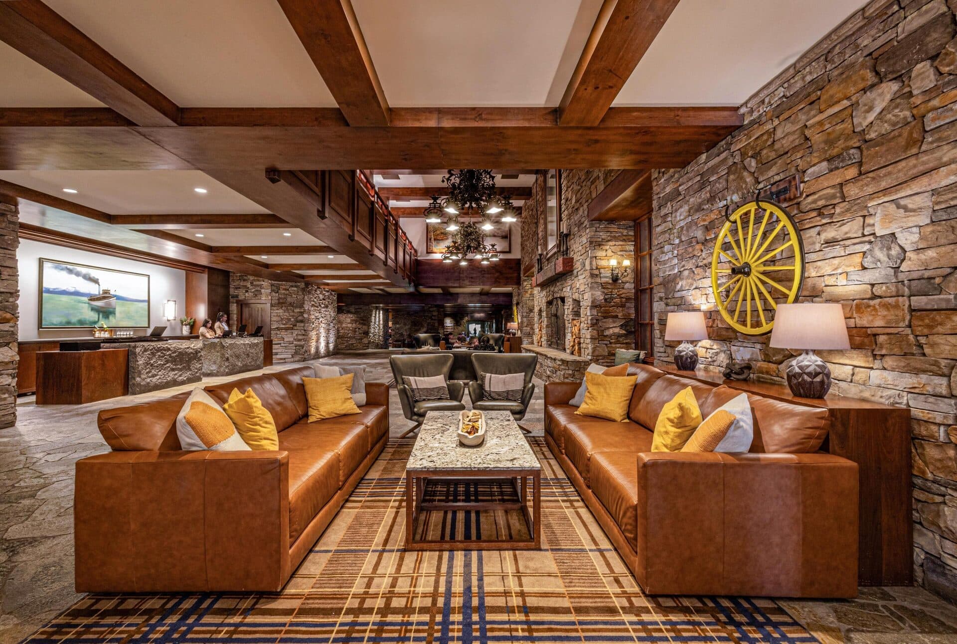 Grand Lodge lobby with stone fireplace, leather couches, and pendant lighting at Hyatt Regency Lake Tahoe