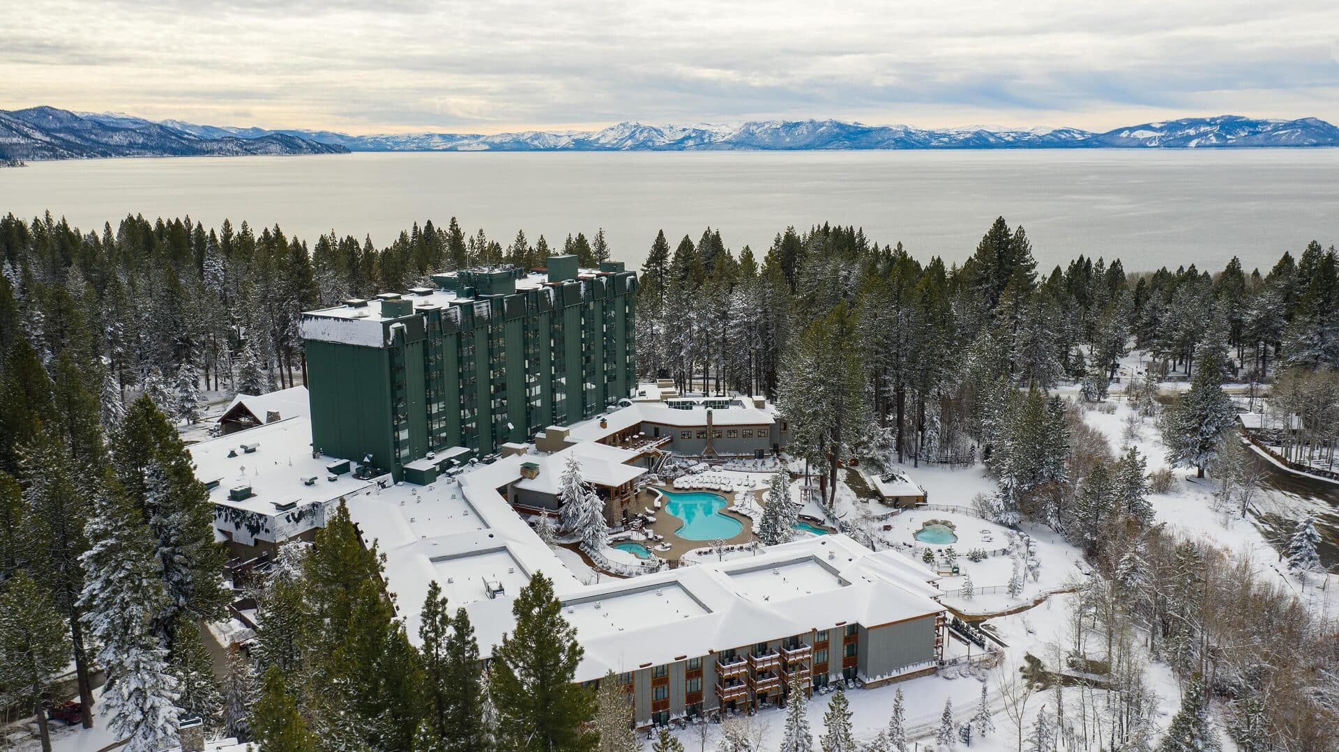 Aerial view of Hyatt Regency Lake Tahoe resort in winter with snow and surrounding pine forest